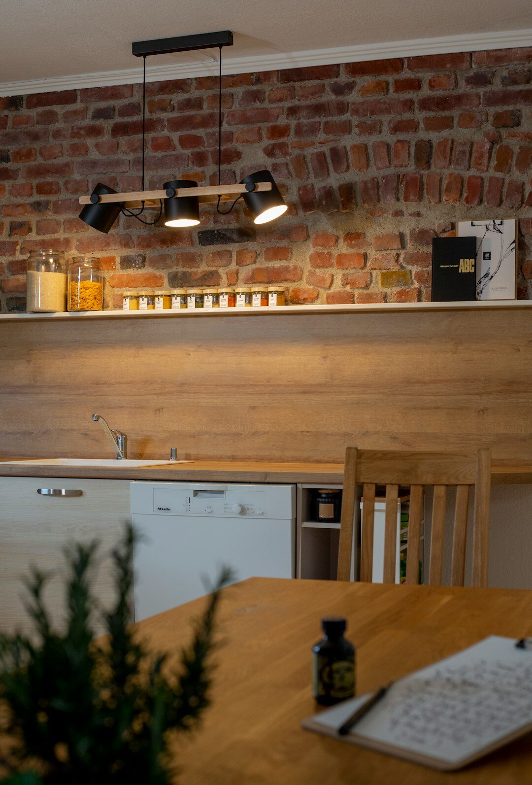 Warm modern Czech home kitchen interior with a wooden table and ceramic dishes